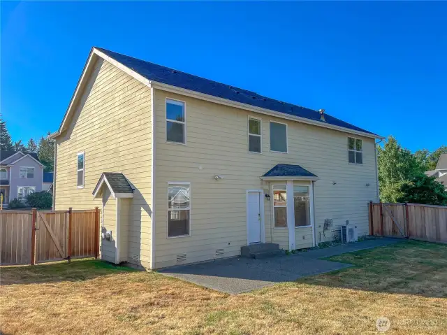 Back of house featuring two fence gates, and patio area for outdoor cooking, dining and entertainment.