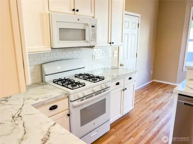 Propane range provides dependable cooking. Door to the attached garage door.