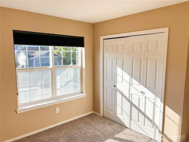 First bedroom with double windows & closet doors.