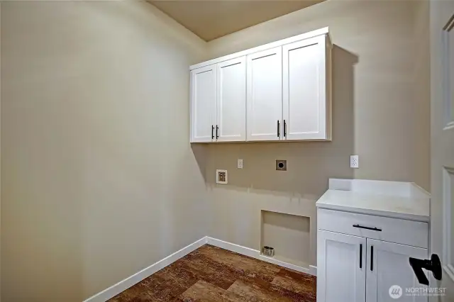Laundry room has luxury vinyl flooring and cabinets with soft close.