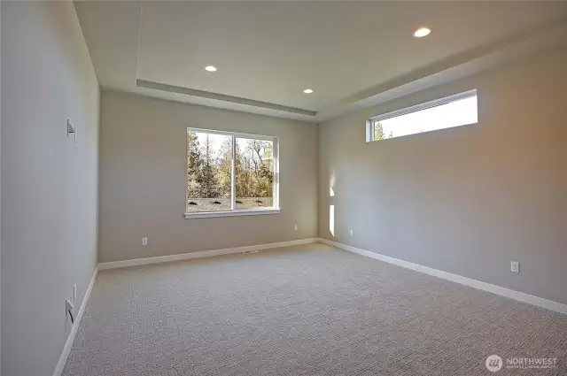 Primary bedroom has a coffered ceiling and lots of light.