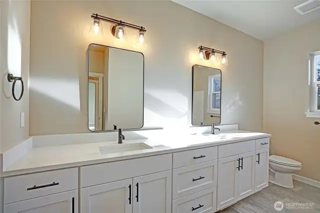 Full guest bathroom with double sinkd, bathtub and shower.  Luxury final flooring.