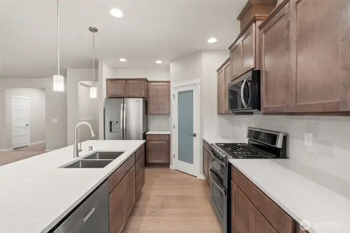 Great workspace and flow through the kitchen. Stainless steel Whirlpool multi-cycle dishwasher, microwave hood and double oven are all standard! This home also includes refrigerator.
