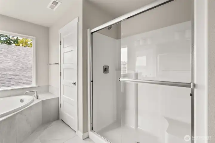 Primary bathroom includes a private water room and standing shower with clear glass doors.