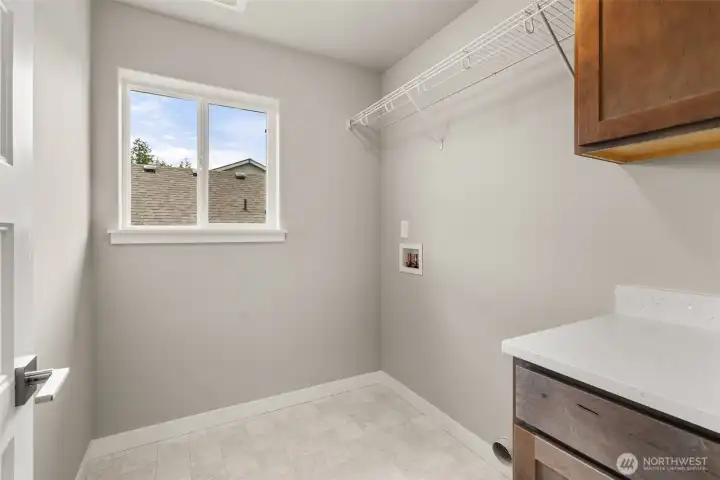 Laundry room on the second floor for convenience. Features upper and lower cabinets plus quartz countertop.