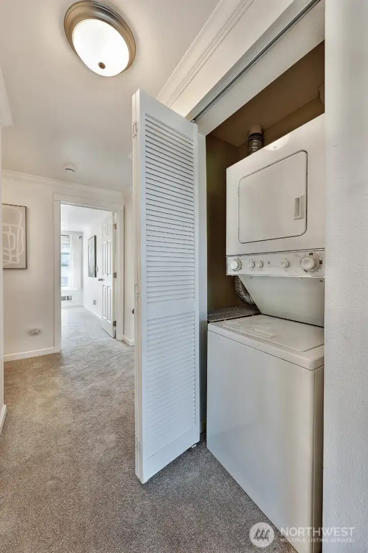 Utility closet with stacked washer and dryer.