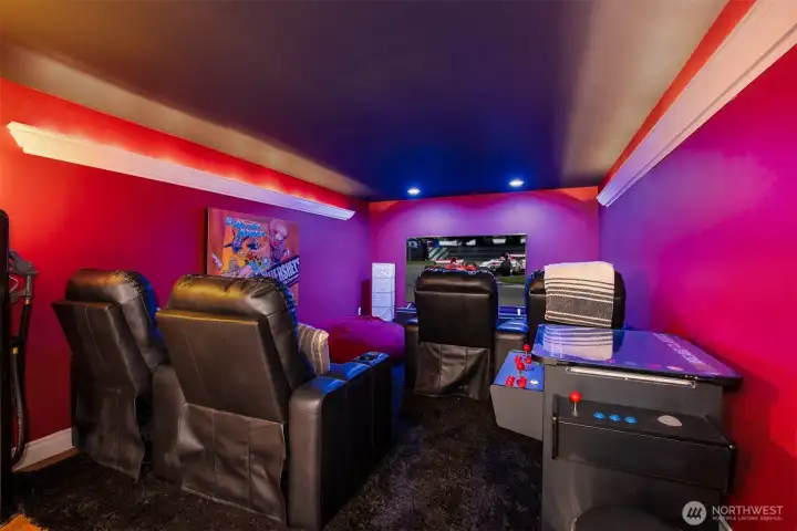 A dedicated theater room delivers a true cinematic experience. Plush seating, dramatic wall color, and immersive lighting create a private screening space perfect for movies, sports, or late-night gatherings.