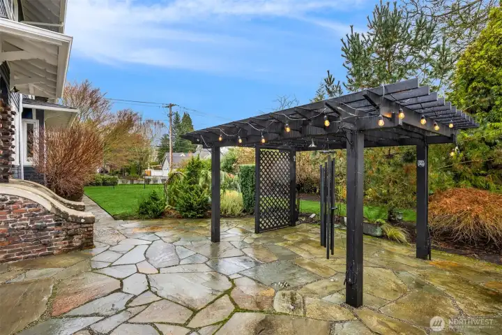 The backyard is unexpectedly expansive and beautifully curated, featuring a stone patio, pergola with ambient lighting, manicured lawn, and layered garden beds. Fully enclosed and thoughtfully designed, it offers privacy, versatility, and year-round enjoyment — equally suited for entertaining or quiet moments at home.