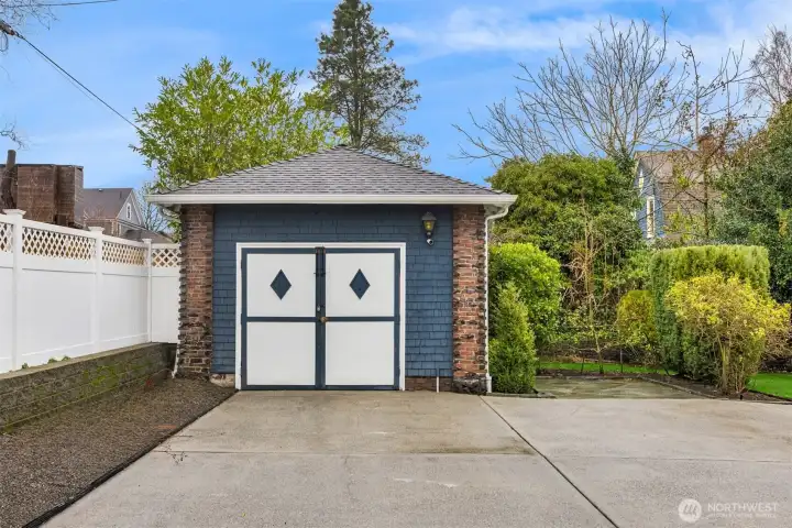 A carriage house garage mirrors the home’s architectural character, blending seamlessly into the property while offering secure parking and additional storage.
