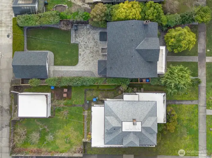 From a bird's eye view, you’ll notice the brand-new roofs on both the home and garage, along with the expansive hardscaped patio that spans the  width of the backyard—complete with a high-end, self-cleaning hot tub for year-round relaxation.