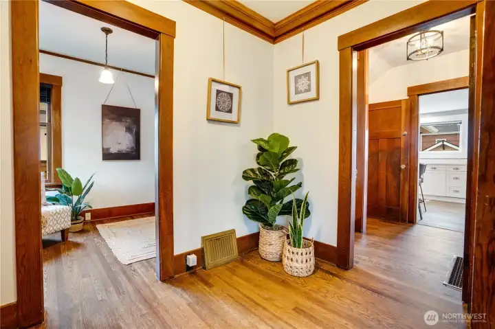 The formal entry showcases fresh paint, refinished hardwood floors, and stunning original millwork with classic crown molding.