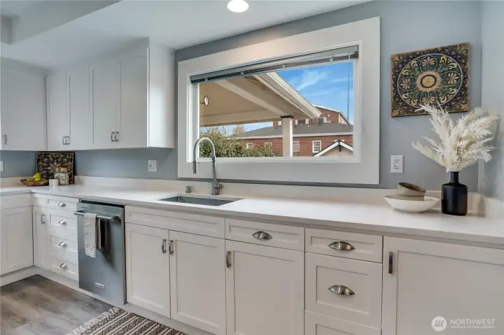 Large picture windows make meal prep a pleasure, while classic hardware complements the kitchen’s timeless style.