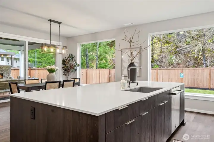 At the center of it all, a spacious quartz island with breakfast bar seating creates the perfect setting for casual meals, prep, and connection.