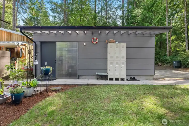 View of the garage from the home, man door leads to a shop area with built-in storage.