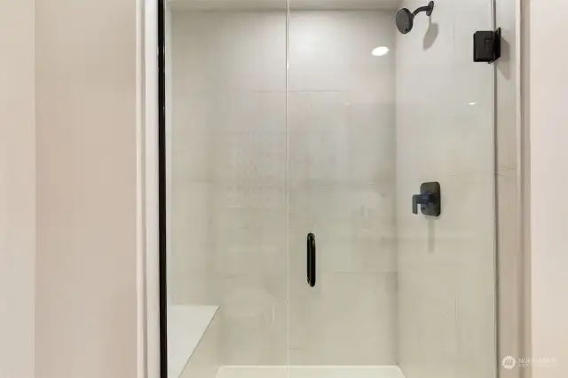 Walk-in shower w/seat in primary ensuite bathroom. ALL PHOTOS ARE OF OUR STAGED MODEL, FINISHES MAY VARY.