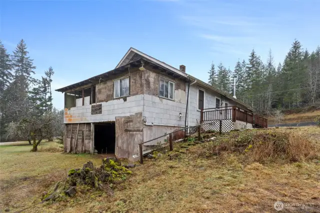 Back portion of home is an upper porch, lower wood shed