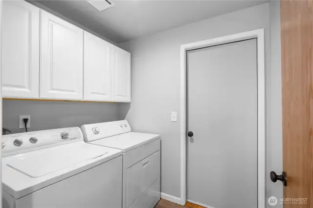 Laundry and utility room. New cabinets add to the storage and use of this room.  Door leads to the 2 car garage with built in shop area.