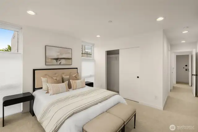 Primary bedroom features floor-to-ceiling windows, custom window treatments, carpet and an ensuite.