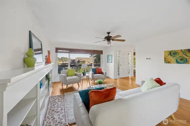 Mid-century styling with classic white walls, rich wood floors, a glass brick side-light entry door, large view windows, ceiling fan and loads of built-ins, wait for your special touch.