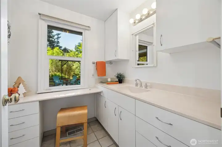 Loads of counter space and a classic "dressing table" counter make up the grooming portion of the full bath.  Courtyard view window brings in natural light and fresh ventilation.