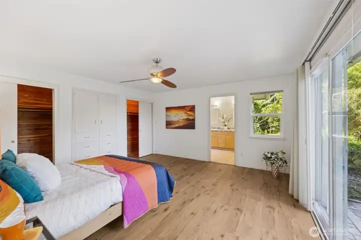 The upgraded, large primary suite with 4 piece bath features sliding glass doors to the courtyard and views, cedar lined closets and laminate plank flooring.  The ceiling fan moves the inlet breezes to cool the space in summer.