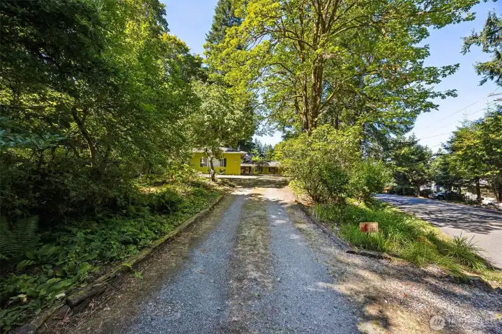 A long, fairly level driveway intersects the second lot and leads to the level shop parking area with turn around space, RV parking space, a large detached shop and the side entrance used as the primary access commonly.