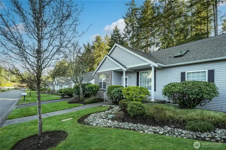 These duplex-style condos are situated along a quiet, tree-lined street, creating an idyllic atmosphere.