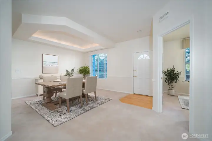 The dining room, just off the entry, features a chair rail and tray ceiling, giving the space an upscale feel. Virtually Staged.