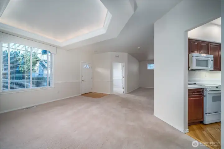 A view showing the seamless connection between the dining room, kitchen, den/office, and living room beyond.