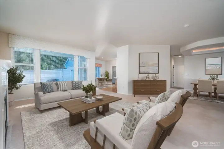 A perspective highlighting how the living room flows effortlessly into the dining room and kitchen. Virtually Staged.