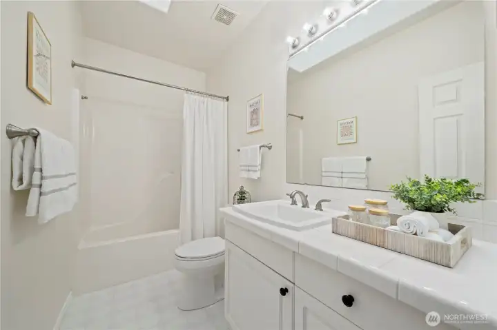 The full guest bath also features a skylight,   adding warmth and natural light.
