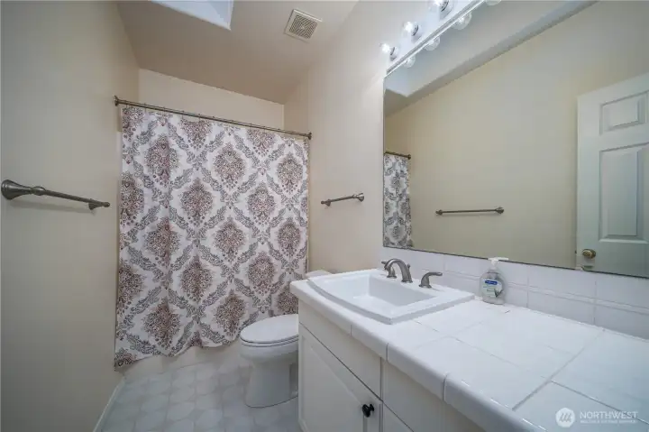The full guest bath also features a skylight, adding warmth and natural light.