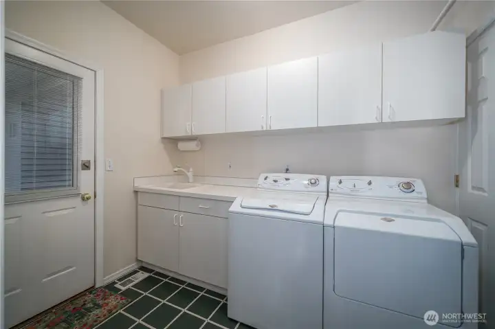 Just off the kitchen is the utility room with washer and dryer, utility sink, and ample storage. The covered breezeway to the 2-car garage is just through this door.