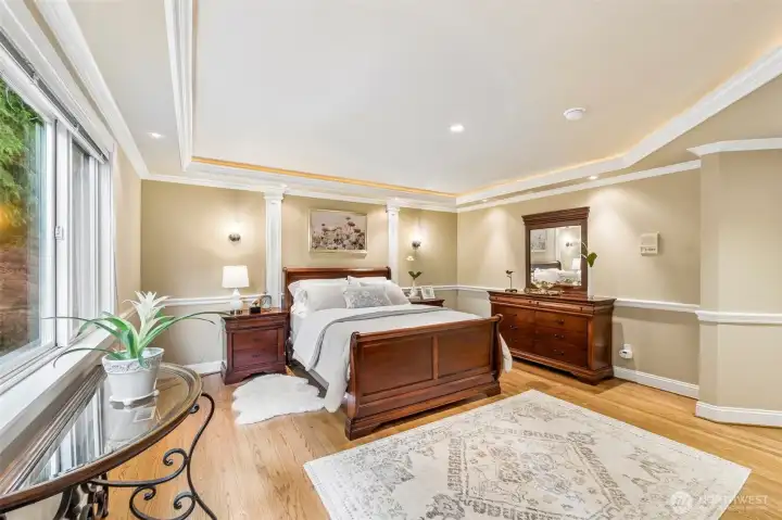 Primary bedroom has hardwood floor & beautiful finishes