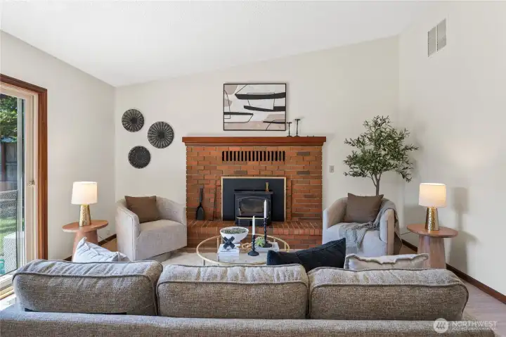 Family room view with wood burning fireplace.