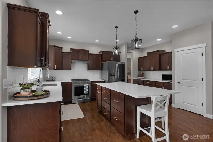 A kitchen that checks every box. Featuring quartz countertops, rich cabinetry, stainless steel appliances, and an oversized island perfect for gathering, meal prep, or morning coffee