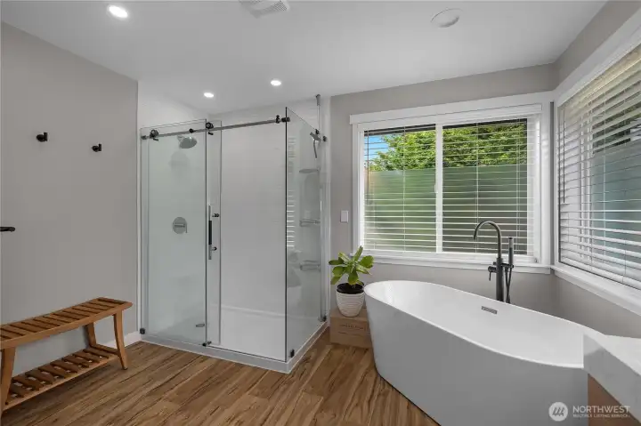 Featuring dual vanities, modern finishes, a separate glass shower, and a relaxing soaking tub.