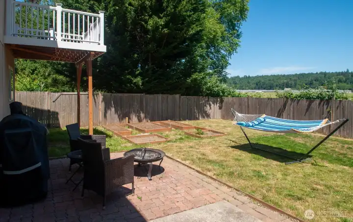 The backyard has several raised-bed planting areas as well as a patio. The backyard has several raised-bed planting areas as well as a patio.