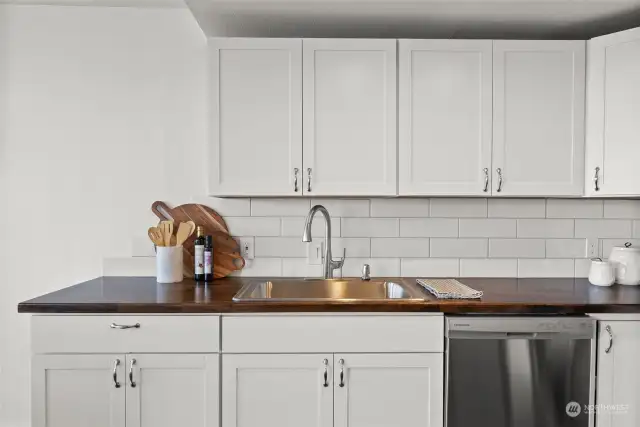 Stainless steel appliances complement the kitchen hardware, creating a harmonious and stylish, modern look.