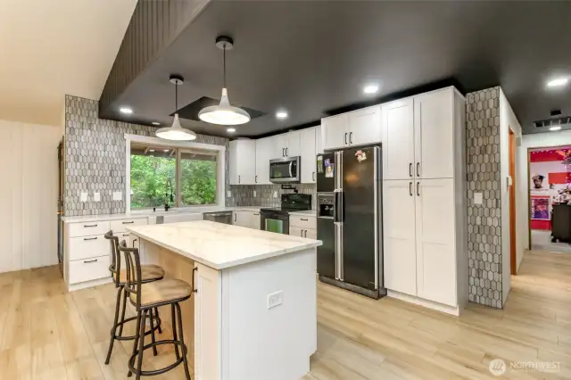 Remodeled kitchen with quartz counter top and island & beautiful backsplash