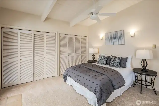 Primary Bedroom with ensuite bathroom, a wall of closet space, and a private hot tub just outside on the patio.