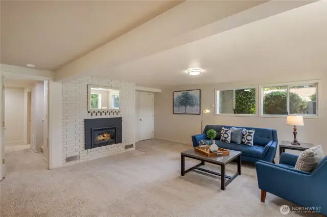 Spacious and bright rec room with gas fireplace and view of Pine Lake.  The bathroom and laundry room are down the hallway on the left of the fireplace.  The door on the right goes to the large storage/shop area.