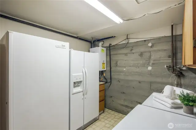 Large downstairs utility room with...plenty of room for that extra fridge and freezer.  notice the tankless water heater.   There is a nice wash tub too.