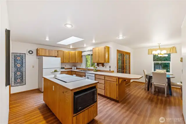 Spacious kitchen with center island, breakfast bar seating, and adjacent dining area—perfect for everyday meals or entertaining.
