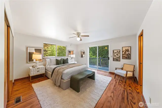 Primary suite with ceiling fan comfort and private deck overlooking the fenced backyard—wake up to the sound of birds and your own peaceful retreat.