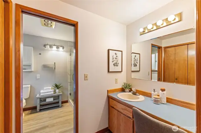 Primary en suite bath includes an extended vanity and dressing area with convenient storage.