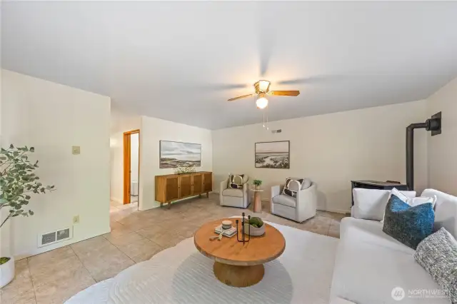 Spacious family room features a pellet stove for efficient warmth, tile floors, and flexible space for relaxing or entertaining.