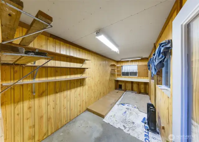 Dedicated storage area with paneled walls, built-in shelving, and electricity for organized tools, gear, or seasonal items.