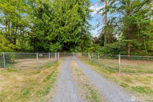 Fenced entry with gated driveway provides added privacy and security as you enter this peaceful 5-acre Arlington retreat.