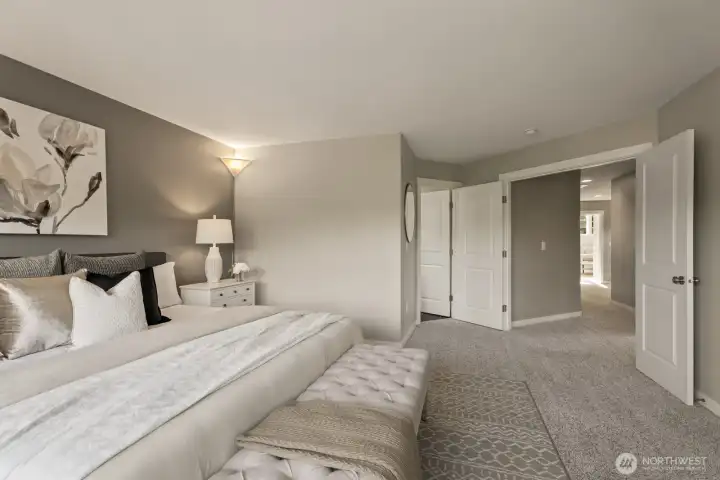 Additional view of the primary bedroom highlighting the generous space and stylish double-door entry.(staged picture)